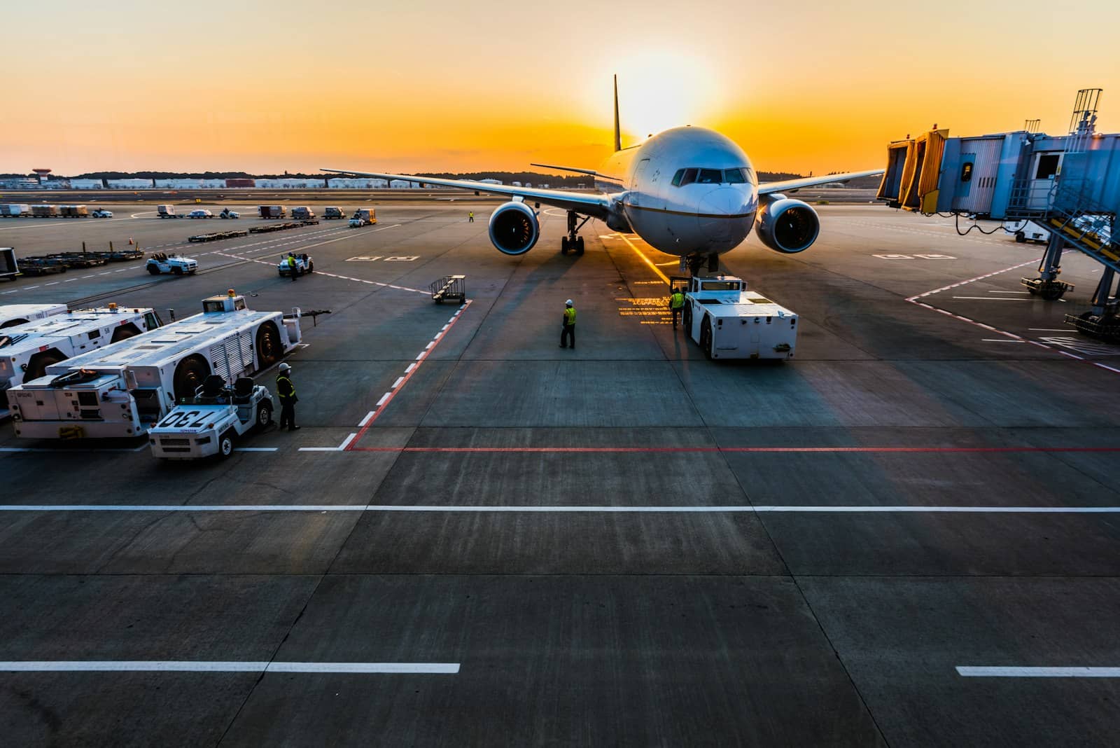 Passenger jet parked at the gate as the sun sets over the airfield